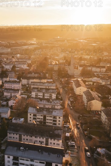 Residential areas in a city under a warm sunset sky, with glowing streets, Calw, Black Forest, Germany
