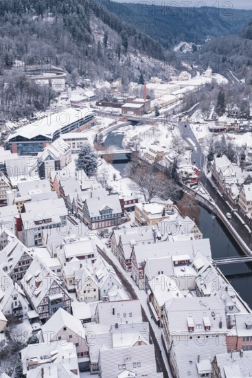 Snowy cityscape with river, bridge and hilly surroundings in the background, Calw, Black Forest, Germany