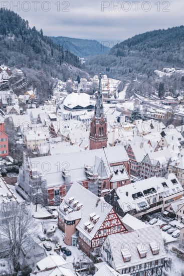 Snowy old town with distinctive church and half-timbered houses in mountainous surroundings, Calw, Black Forest, Germany