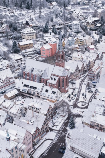 Snowy town with a distinctive church surrounded by traditional architecture, Calw, Black Forest, Germany