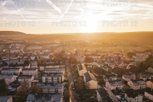 City view at sunset with residential buildings, hills and a colorful sky, Calw, Black Forest, Germany