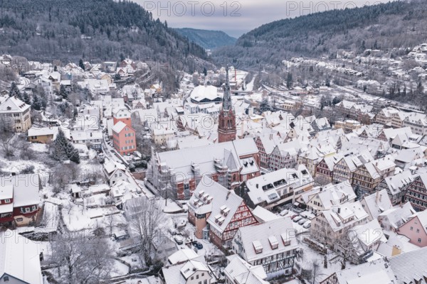 Snowy cityscape with a central church surrounded by traditional buildings and hills, Calw, Black Forest, Germany