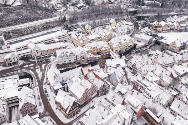 Urban winter landscape with snow-covered roofs and half-timbered houses in the old town, Calw, Black Forest, Germany