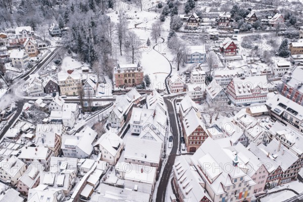 Snowy urban landscape nestled in a hilly area with traditional houses, Calw, Black Forest, Germany