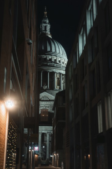 Illuminated St Paul Cathedral through narrow alley at dusk, historic backdrop, London, England, Great Britain