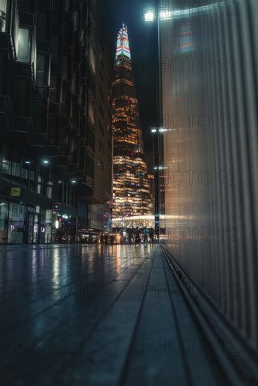 Tall illuminated skyscraper, people on the street, Shard, London, England, Great Britain