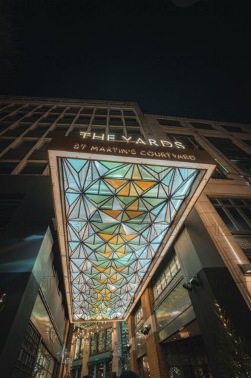 Entrance with modern geometric design and colorful lights at night, London, England, Great Britain
