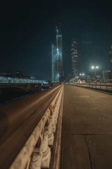 Night scene of an illuminated bridge with skyscrapers in London, London, England, Great Britain