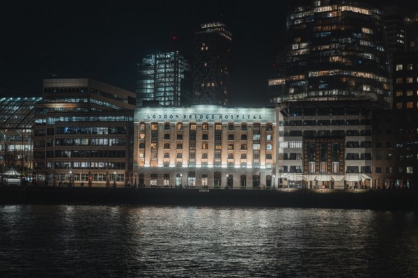Nighttime building on the river with lights and reflected water in London, London, England, Great Britain