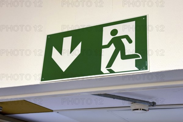 Sign with escape route emergency exit pictogram and down arrow, Germany