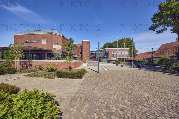 Town Hall, Restaurant Ratskeller bei Petro, brick building, modern architecture, brick wall, entrance, staircase, lantern, flag, flagpoles, concrete paving stone and paving stone walkway, flower bed, blue sky, cirrus clouds, dam, district of Vechta, Lower Saxony, Germany