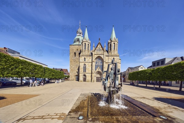 St. Victor Church, Victor Fountain, sculptor Ferdinand Starmann, general architecture, trees, pedestrians and seated people as secondary motifs, blue sky, cirrus clouds, Kirchplatz, Damme, Vechta district, Lower Saxony, Germany