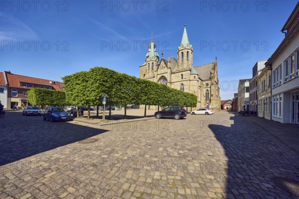 St. Victor church, general architecture, square made of paving stones, parking boxes with cars, trees, blue sky, cirrus clouds, Kirchplatz square, Damme, district of Vechta, Lower Saxony, Germany