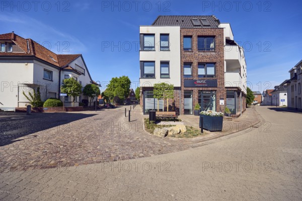 Acoustician Buse hearing acoustics, general architecture, residential and commercial buildings, apartment buildings, bench, barrier bollard, flower pots, trees, blue sky, cirrus clouds, intersection Große Straße with Donaustraße, Damme, Vechta district, Lower Saxony, Germany