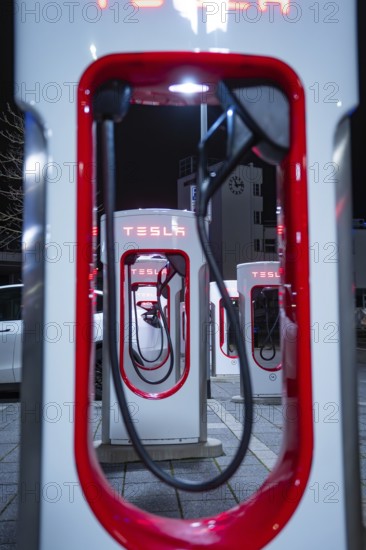 Tesla charging stations at night with red lighting and modern optics, Tesla Supercharger, Böblingen, Germany