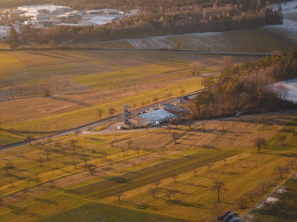Aerial view of a landscape surrounded by fields in the evening light with a small village in the distance, Althengstett, fire station, Calw district, Germany