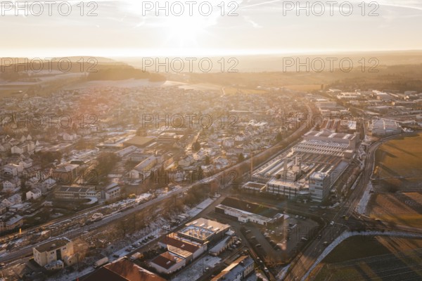 Sunset over a town with fields and industrial complexes in the foreground, Althengstett, Calw district, Germany