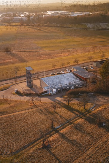Fire station in a rural winter landscape with long shadows and snow-covered fields, Althengstett, Calw district, Germany