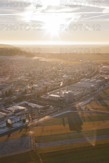 Aerial view of a city at sunset with snow-covered fields and shadow effects, Althengstett, Calw district, Germany