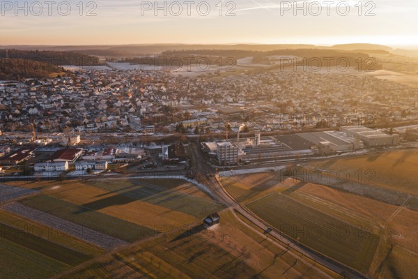 View of an urban landscape at dusk, surrounded by fields and under a wide sky, Althengstett, Calw district, Germany