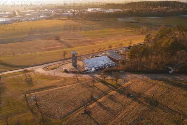 Aerial view of a landscape in evening light with fire station surrounded by fields and trees, Althengstett, Calw district, Germany