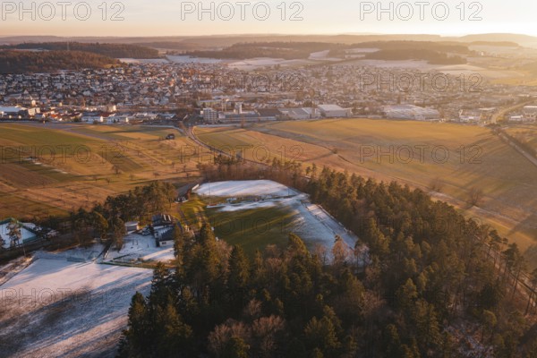 Extensive view of a snowy landscape with a sports field and surrounding trees, Althengstett, Calw district, Germany