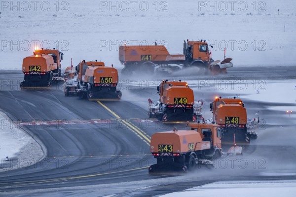 The onset of winter in North Rhine-Westphalia, flight operations are maintained at Düsseldorf Airport with great effort, the taxiways and runway are being freed from snow and ice with many clearing vehicles, North Rhine-Westphalia, Germany