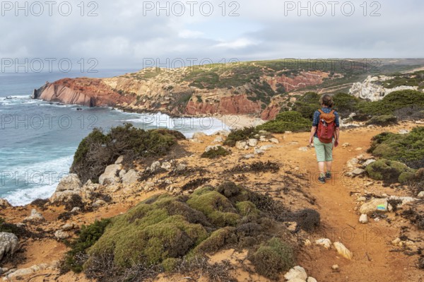 Hiking woman, view over cliff, Fishermens Trail, Rosa Vicentina, western Algarve just north of cape Cabo de Sao Vicente, Portugal