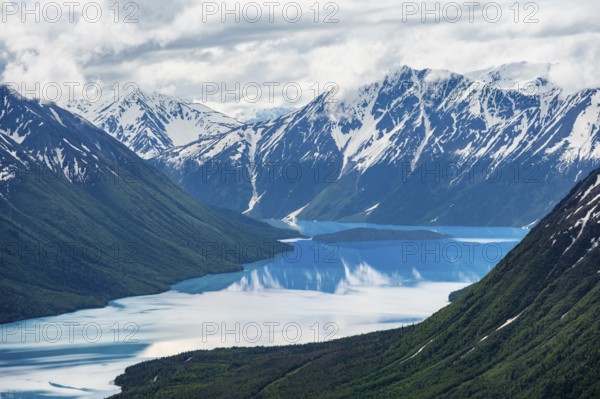 View of snowy mountains in spring and turquoise Kenai Lake with reflection, Slaughter Ridge Trail, Cooper Landing, Kenai Peninsula, Alaska, USA