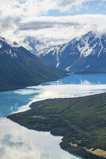 View of snowy mountains in spring and turquoise Kenai Lake with reflection, Slaughter Ridge Trail, Cooper Landing, Kenai Peninsula, Alaska, USA