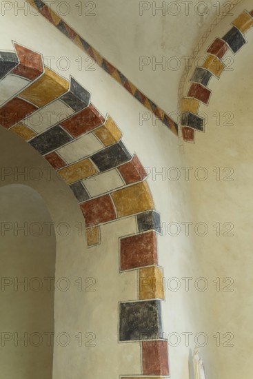 Painted arch in red, yellow and black. St Aignan's Church of Begues. Allier department. Auvergne Rhone Alpes. France. Europe