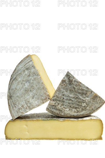 Three pieces of Saint-Nectaire cheese are stacked on top of each other. Puy de Dome. Auvergne. France