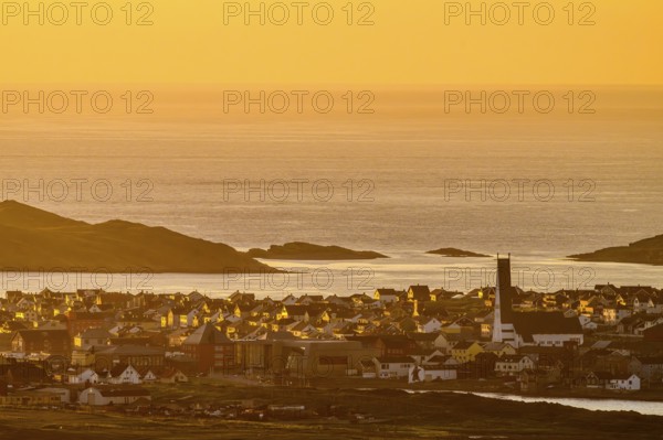 View of the city of Vardø from Mount Domen, sea at sunset with golden sky and calm atmosphere, Kiberg, Finnmark, Norway