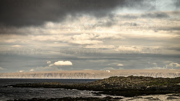 Atmospheric coastal landscape with cloudy sky over a vast sea on the coastal road in the north of the Varanger Peninsula, Berlevåg, Finnmark, Norway