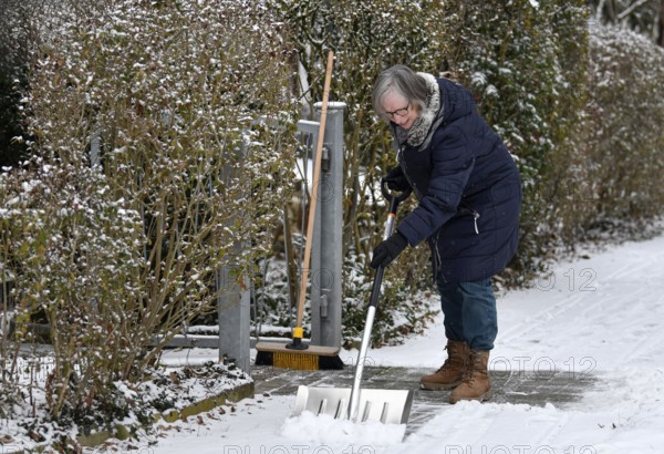 Elderly woman sweeping week with snow shovel, snow shovel, snow remover, shovel, clear, shovel snow, sidewalk, snowfall, snow, winter, Stuttgart, Baden-Württemberg, Germany