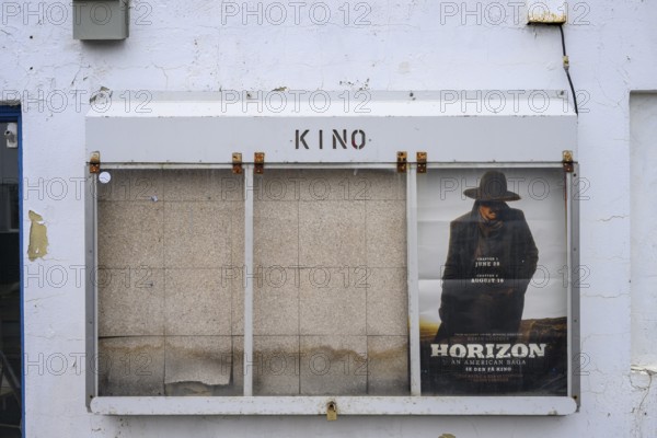 Cinema poster on a white painted wall with some peeling paint, Berlevåg, Finnmark, Norway
