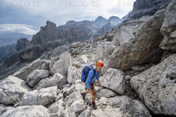 Mountaineers among large boulders, rocky mountain landscape, Via Ferrata SOSAT via ferrata, Brenta Mountains, Trentino, Italy