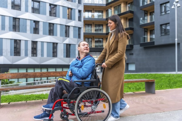 Young woman smiling as she pushes a man in a wheelchair along an accessible city street, showcasing inclusion, support, mobility and independent urban life together