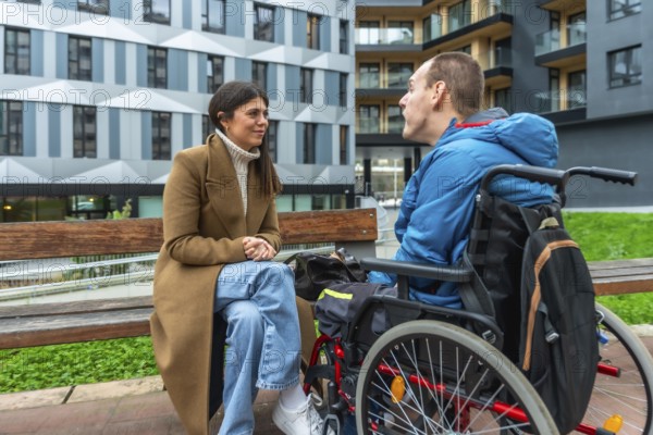 Woman and man with cerebral palsy sitting together by a bench, having a conversation in an urban setting, representing support, care, and social inclusion