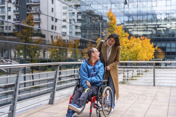 Caregiver pushing an adult man in a wheelchair on a modern city street, both individuals smiling and engaging in conversation, representing inclusion, support, and mobility