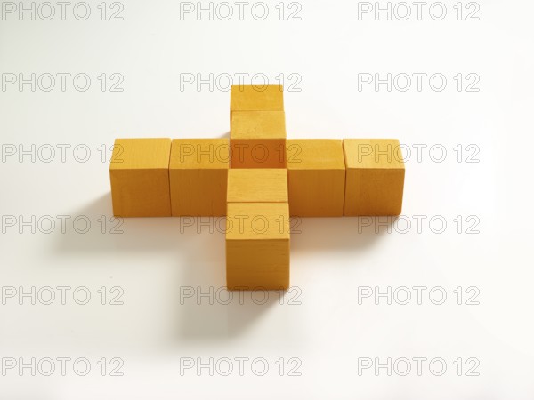 8 yellow wooden cubes against a white background