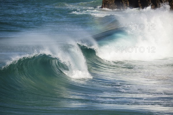Waves crash against rocks at the mainland's easternmost point, creating rainbows in the ocean spray. Daylight, Byron Bay, New South Wales, Australia
