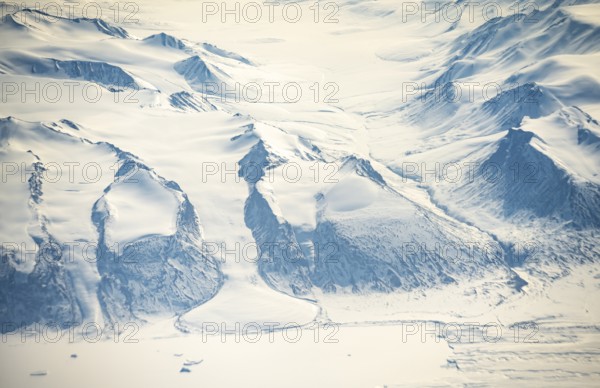 Glacier tongue flows into huge glaciers, snowy arctic mountain landscape, aerial view, Greenland, Arctic