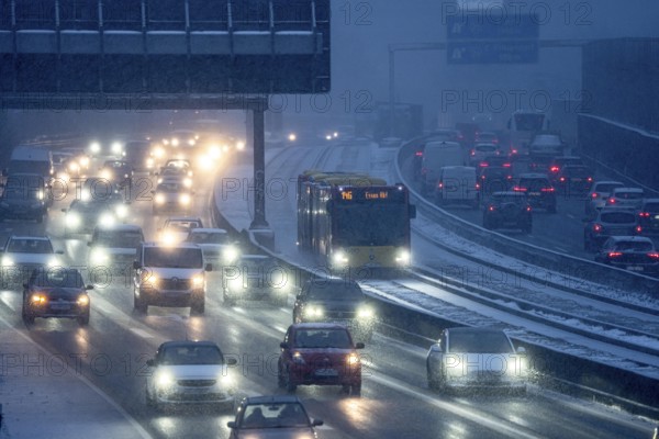 Winter weather, motorway traffic, A40 motorway, Ruhrschnellweg, in Essen, at the Essen-East motorway junction, snowfall, traffic jams, heavy flowing traffic, bus lane between roads, public transport, North Rhine-Westphalia, Germany