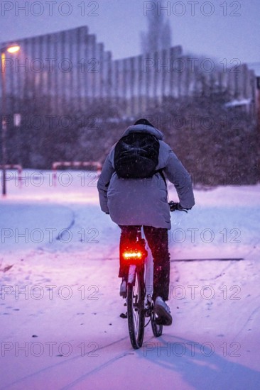 Winter weather, blowing snow, person with e-bike, bicycle on snowy road, North Rhine-Westphalia, Germany
