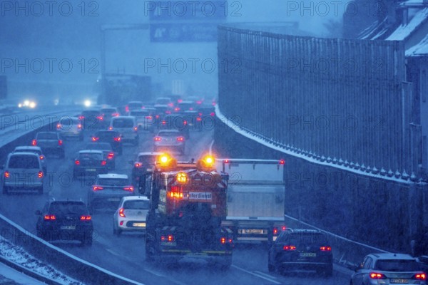 Winter maintenance, spreading vehicle, winter weather, motorway traffic, A40 motorway, Ruhrschnellweg, in Essen, at the Essen-Ost motorway junction, snowfall, traffic jams, heavy flowing traffic, North Rhine-Westphalia, Germany