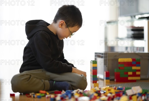 Boy, 6 years, glasses, multi-ethnic, plays with Lego, concentrates, constructs, builds, Stuttgart, Baden-Württemberg, Germany
