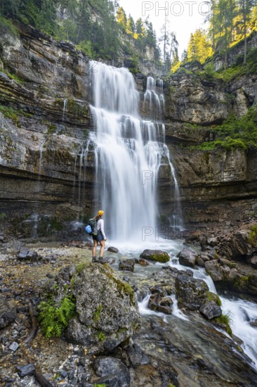 Young woman in front of Cascata di Mezzo waterfall, long exposure, Vallesinella, Brenta, Trentino, Italy