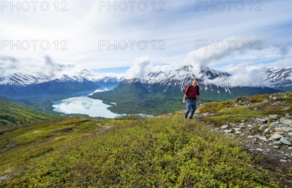 Climbers on a hiking trail, Slaughter Ridge Trail, view of snowy mountains and turquoise lake Kenai Lake, Cooper Landing, Kenai Peninsula, Alaska, USA