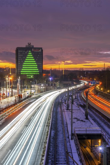 Autobahn A40, Ruhrschnellweg, between Essen and Mülheim an der Ruhr, evening traffic in winter, former, now vacant Stinnes high-rise building, at the Rhine-Ruhr Center, showing a green Christmas tree from illuminated windows at Christmas time, North Rhine-Westphalia, Germany